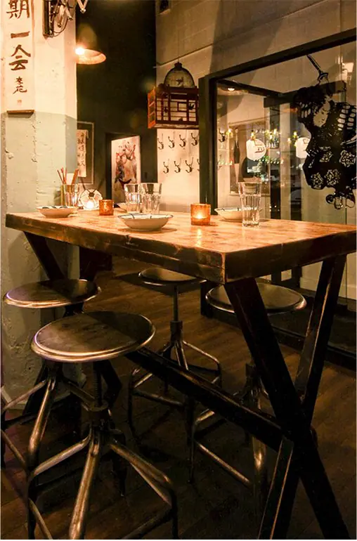 Table haute devant un décor mural