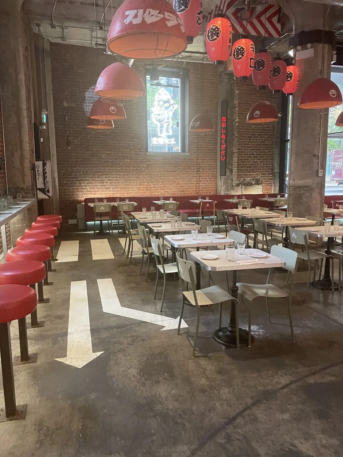 Salle avec flèches peintes au sol et banquettes rouges
